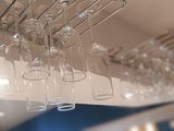 many wine glasses hanging from the ceiling of a restaurant