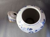 a blue and white vase with a lid sitting on a table