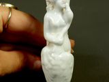 a small figurine of a woman sitting on a table