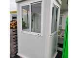 un gros plan d'un petit bâtiment blanc avec une porte verte