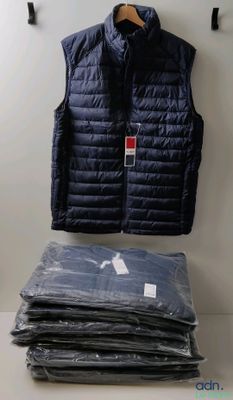 une pile de vêtements pliés posée sur une table, à côté d'un gilet bleu
