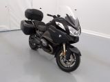 a black motorcycle parked in a room with a white wall