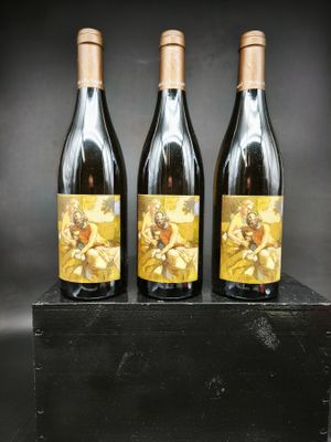 trois bouteilles de vin posées sur une caisse en bois