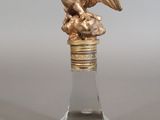 a glass bottle with a statue of an eagle on it