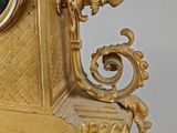a gold clock with a picture of a woman on it