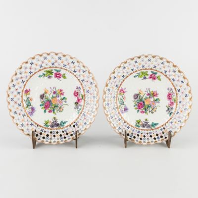 une paire d'assiettes en porcelaine ornées de motifs floraux et bordées d'or