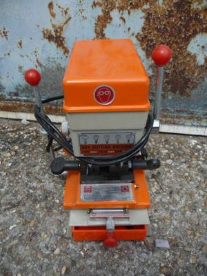 an orange and white machine sitting on top of a cement floor
