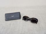 a pair of sunglasses and a black case on a bed