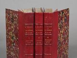 three red books are stacked on top of each other on a gray surface