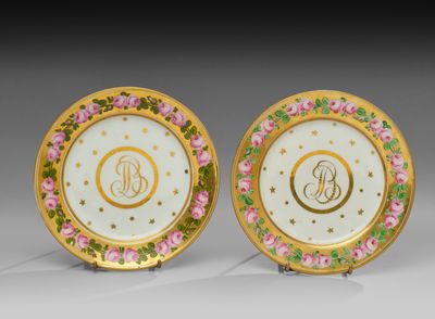 une paire d'assiettes en porcelaine ornées de fleurs dorées et roses