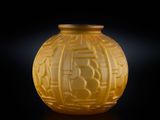 un vase jaune posé sur une table, sur fond noir