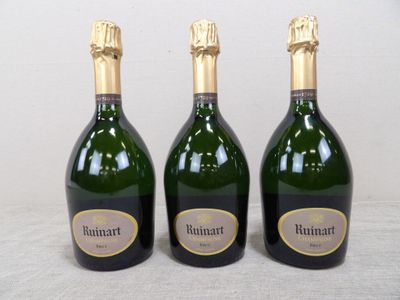 trois bouteilles de vin posées sur une table l'une à côté de l'autre