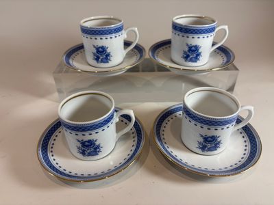 four blue and white cups and saucers sitting on a tray