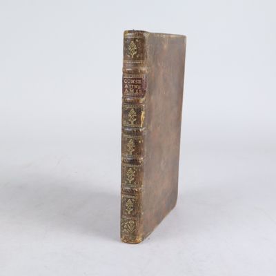 un vieux livre posé sur une surface blanche