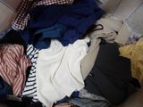 a pile of clothes that is sitting on a couch