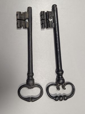 two old keys that are sitting on a table