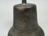 a metal bell that is sitting on a white surface