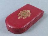 a small red box with a gold emblem on it