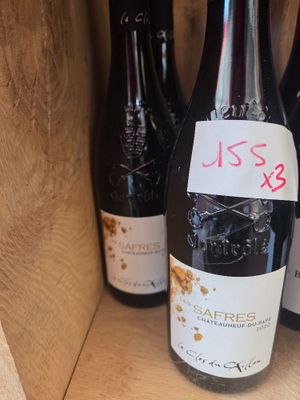 several bottles of wine in a wooden box with a price tag