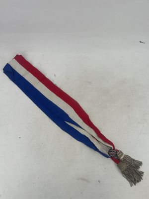 a red, white and blue ribbon with a tassel on it