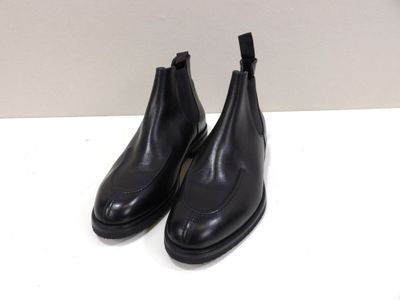 a pair of black leather boots sitting on top of a white table