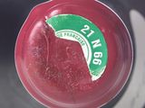 a close up of a red plastic container with a green label on it