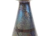 un vase bleu posé sur une surface blanche