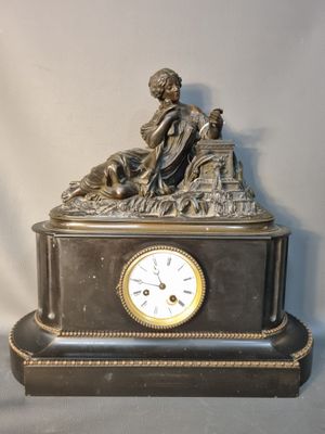 une statue de femme assise au sommet d'une horloge