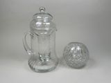 a glass pitcher and a glass ball on a table