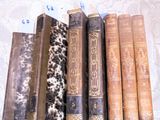 Plusieurs vieux livres sont alignés sur une nappe en dentelle