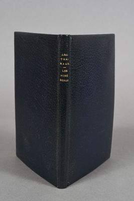 a black book sitting on top of a table next to a white wall