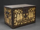 un coffre noir et doré orné de fleurs dorées