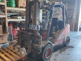 un chariot élévateur garé à côté d'une palette