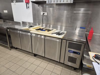 une cuisine équipée de plans de travail et d'appareils électroménagers en acier inoxydable