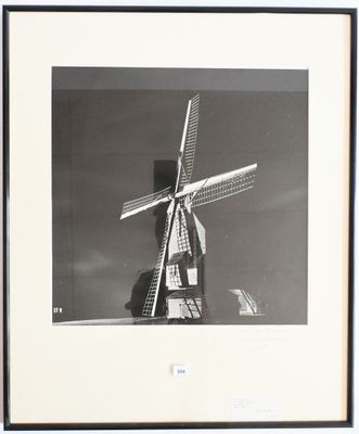 photographie en noir et blanc d'un moulin à vent au milieu d'un champ