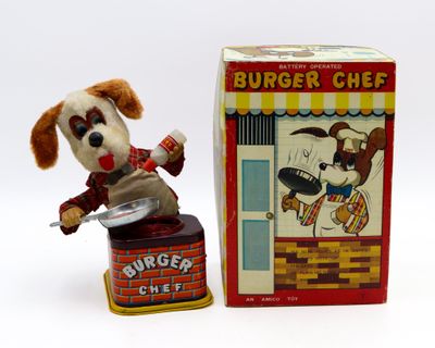 un petit chien en peluche qui se tient à côté d'une boîte de hamburgers