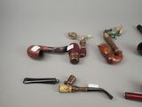 a lot of different types of smoking pipes on the table