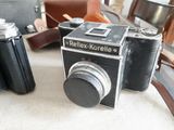 two old cameras sitting on a table next to each other
