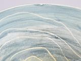 a close up of a blue and white bowl on a table