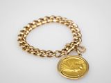 un bracelet en chaîne d'or orné d'une breloque en forme de pièce de monnaie