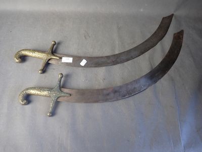 Deux vieilles épées sont posées sur une table, avec des étiquettes accrochées dessus.