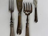 five forks, a knife, and a spoon on a table