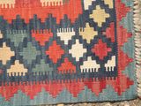 an image of a multicolored area rug on a stone floor