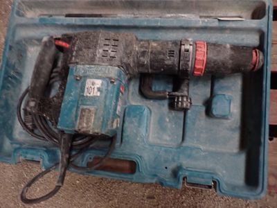une perceuse dans un coffret bleu posée par terre