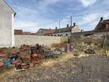 a lot of rusted objects in a field next to a building