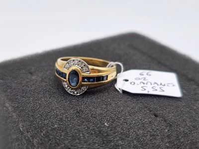 une image d'une bague en or avec une pierre bleue et des diamants