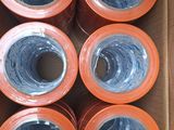 several rolls of orange tape in a box on a table