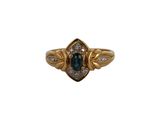 gros plan d'une bague en or avec une pierre bleue et des diamants