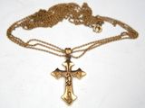 a close up of a cross on a chain on a table