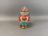 an orange and blue vase sitting on top of a table